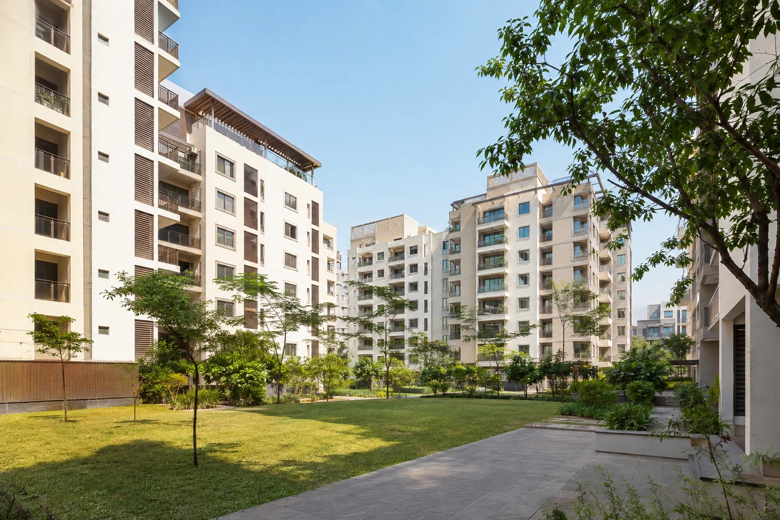 Helle indische Apartmentanlage mit Balkonen, Bäumen, Rasen und gemeinsamem Innenhof